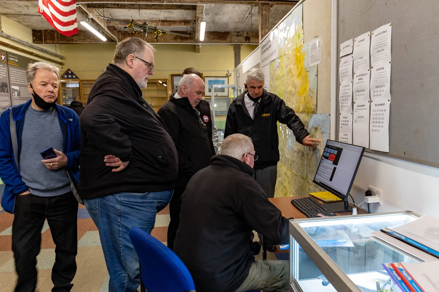 Participants examining maps and research material during the Ulster Aviation Society visit